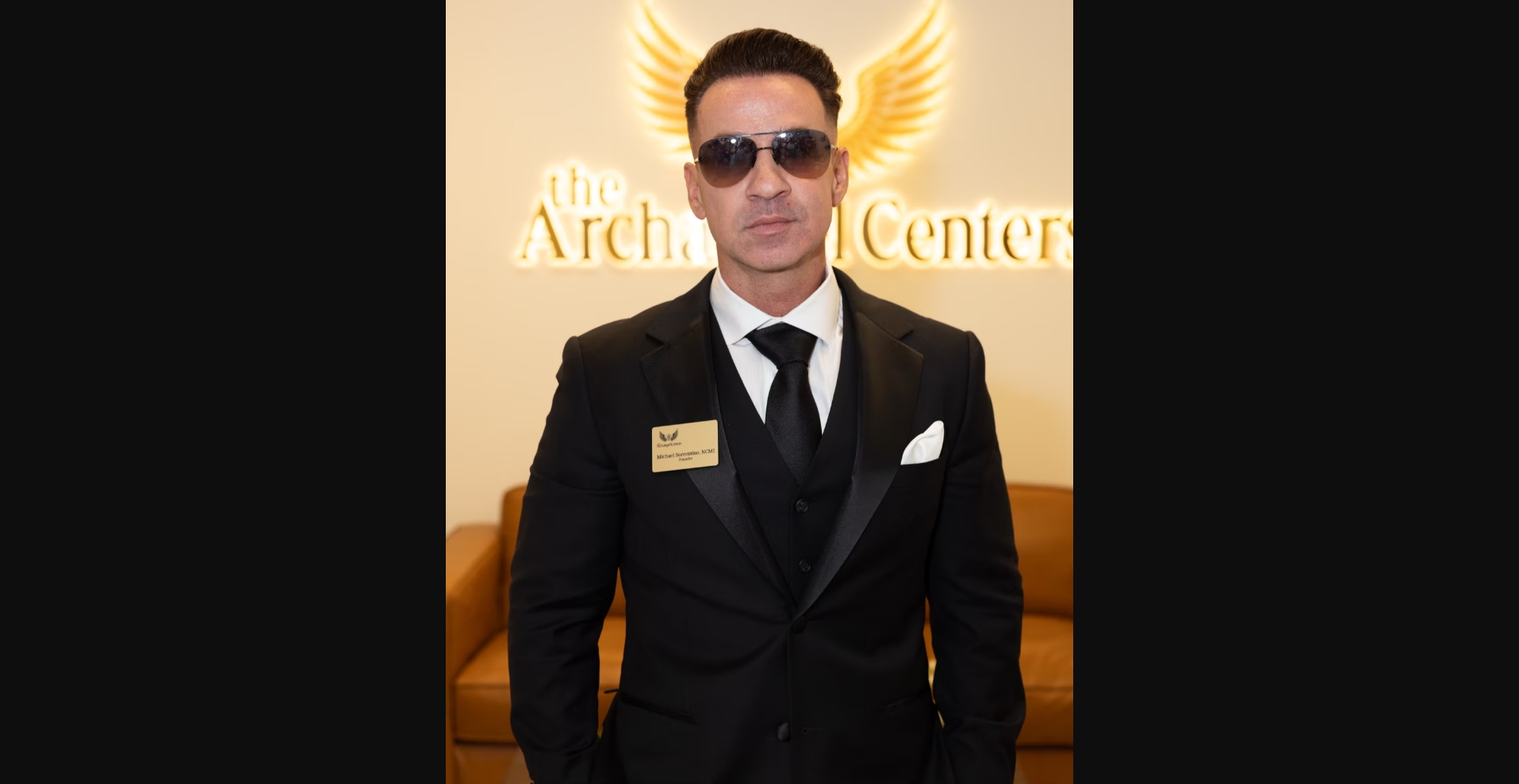 After: Mike's real portrait in black suit at Archangel Centers sign